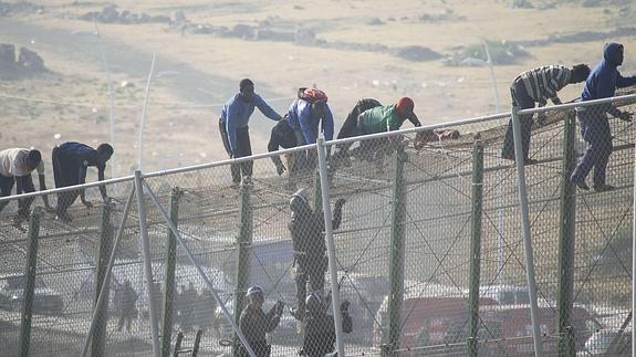 Inmigrantes encaramados a la valla de Melilla. 