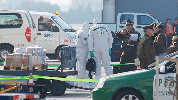 Peritos de Carabineros de Chile trabajan en el lugar donde sujetos asaltaron un camión de valores en la terminal de carga del aeropuerto