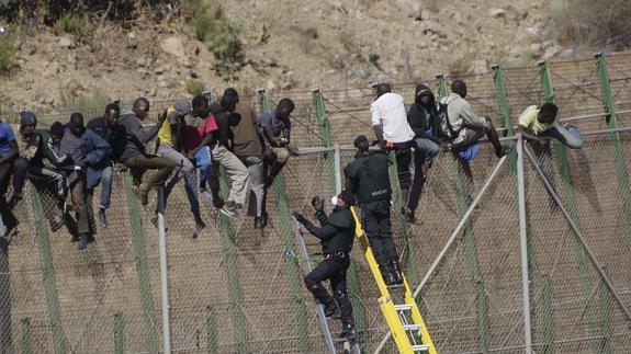 Inmigrantes encaramados a la valla de Melilla. 