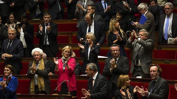 Parlamentarios franceses aplauden el resultado de la votación. 