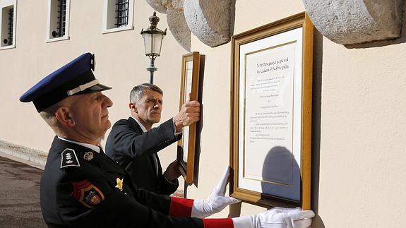 Dos oficiales cuelgan el anuncio oficial del nacimiento de los gemelos de los príncipes Alberto II y Charlene de Mónaco. 