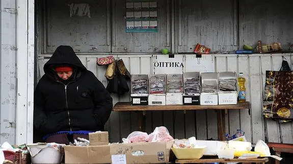 Una mujer se sienta en su puesto en el mercado de Kuibyshev, a dos kilómetros del aeropuerto de Donetsk. 