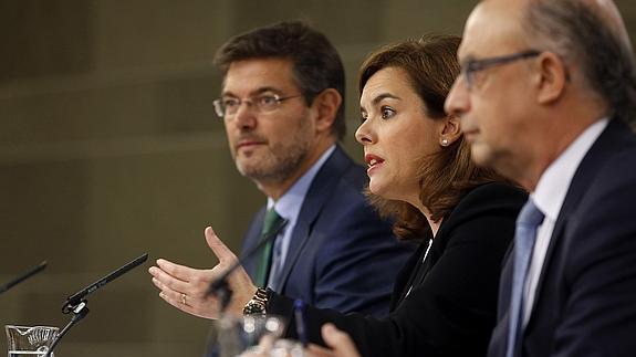 Rafael Catalá, Soraya Sáenz de Santamaría y Cristóbal Montoro, durante el anuncio de la reforma.