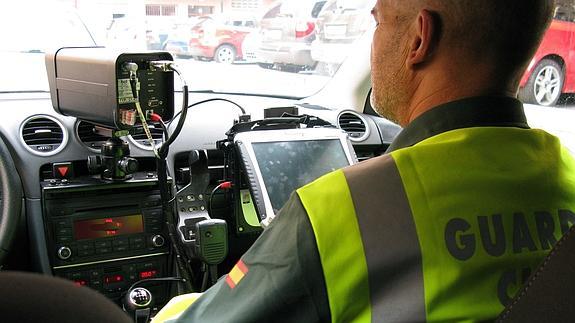 Un guardia civil, con un radar en su coche. 