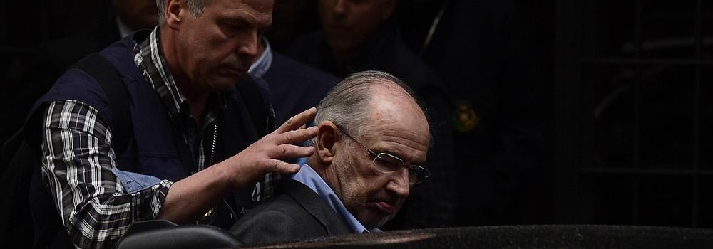 Un agente ayuda a Rodrigo Rato a entrar en el vehículo policial.