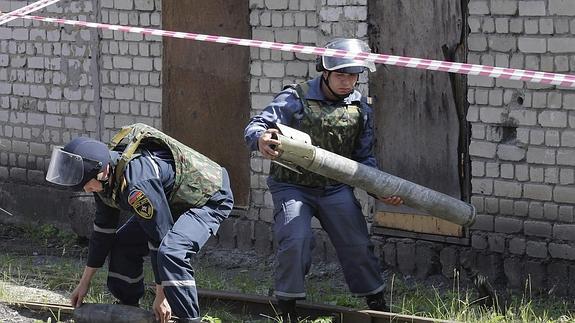 Miembros de un equipo de rescate de la República Popular de Donetsk desactivan un proyectil. 