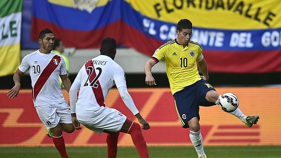 James Rodriguez controla el balón ante los peruanos Joel Sanchez y Carlos Ascues.