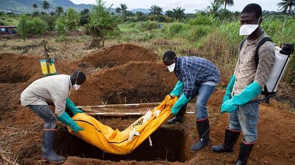 Voluntarios enterrando a una víctima de ébola en Sierra Leona. 