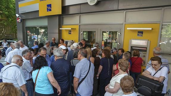 Pensionistas hacen cola para retirar dinero a la entrada de una sucursal bancaria en Salónica, Grecia.