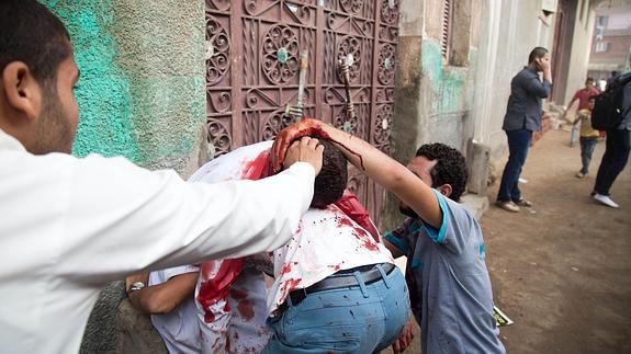 Varios manifestantes socorren a un herido.