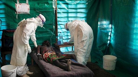 Dos profesionales sanitarios atienden a un hombre con ébola en el Congo. 