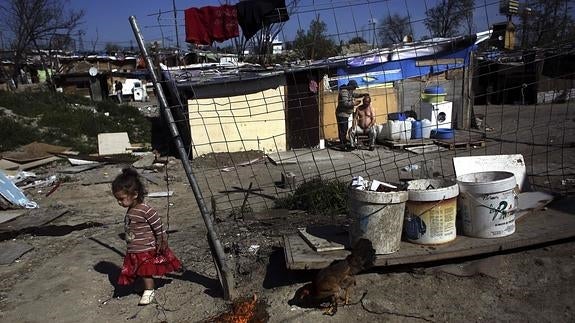 Una niña pasea por una barriada. 