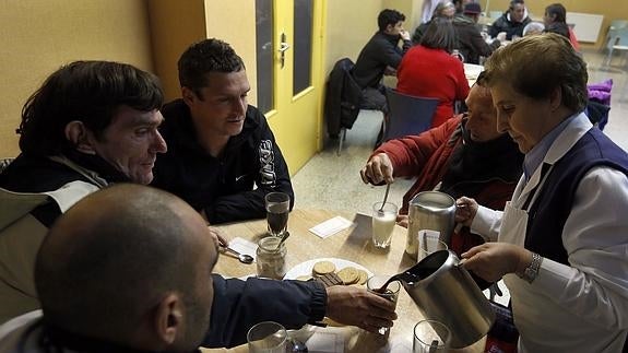 Un grupo de personas en un comedor de Cáritas. 