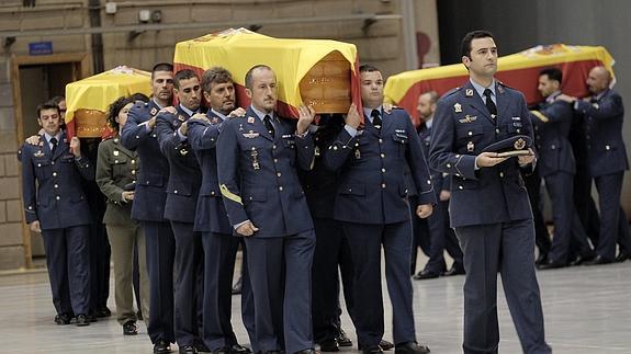 Compañeros de los tres militares fallecidos portan sus féretros en el funeral.