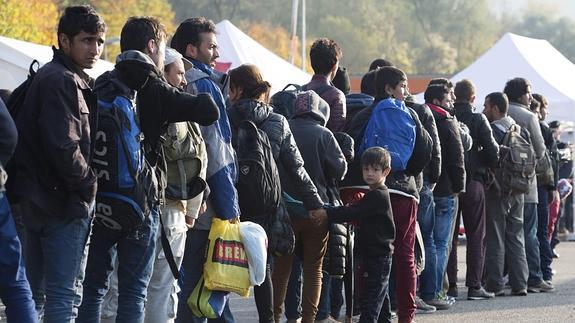 Un grupo de refugiados hace cola en un centro de registro cerca de la frontera entre Austria y Alemania.