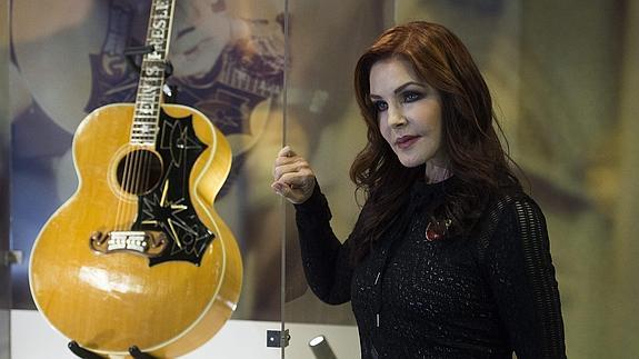 La exmujer de Elvis Presley, Priscilla, posa junto a la guitarra Gibson J-200 del cantante.