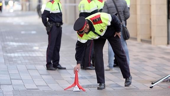 Mossos d'esquadra recogen pruebas en el lugar donde un hombre ha matado a tiros a una mujer.