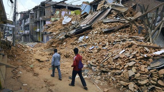 Dos nepalíes caminan entre las ruinas ocasionadas por el terremoto que sacudió el país en mayo.