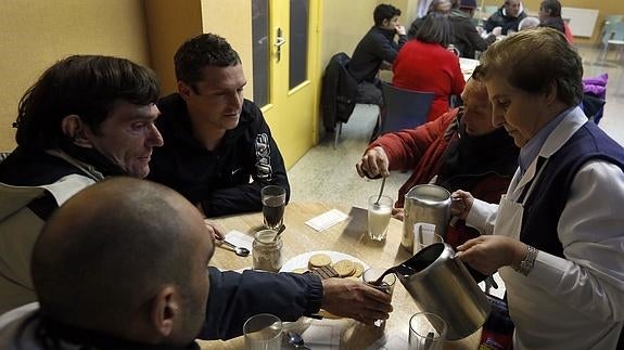 Un grupo de personas en un comedor de Cáritas. 