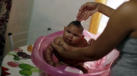 Una mujer baña a su hija en la localidad brasileña de Recife. 