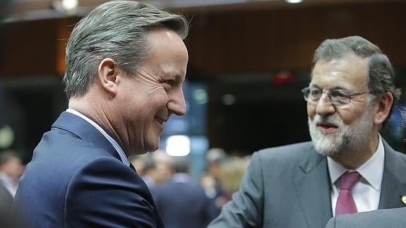 Cameron y Rajoy se saludan en la cumbre de Bruselas.