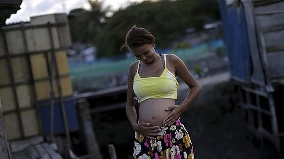 Una mujer embarazada posa frente a su casa en un barrio de chabolas de Recife (Brasil). 