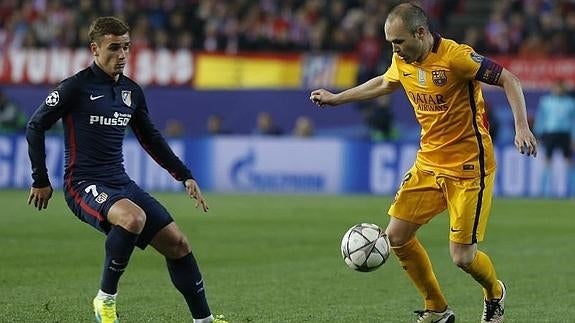 Iniesta (d) controla el balón ante Griezmann. 