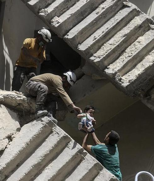 Un niño sirio, evacuado de entre los escombros, tras los bombardeos en la ciudad siria de Alepo. 