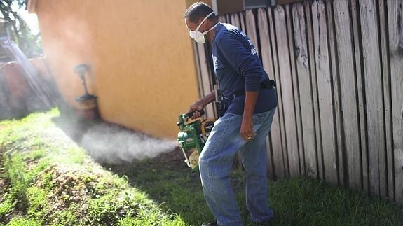 Un hombre desinfecta los jardines por el zika.