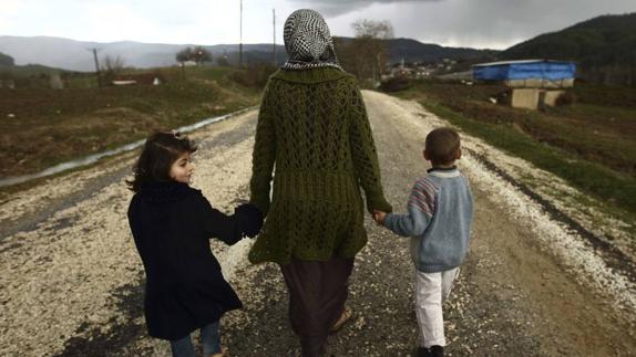 Mujer que ha huido de la guerra de Siria, con sus dos hijos de la mano.