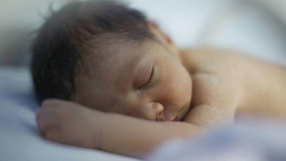 Bebé prematuro durmiendo en una incubadora. 