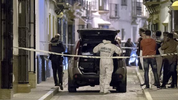 Agentes de Criminalística de la Guardia Civil en la puerta de la vivienda.