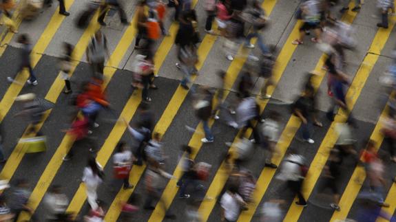 Cientos de personas cruzan por un paso de cebra.