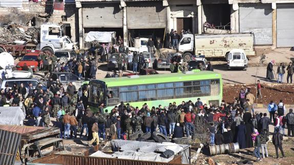 Civiles, combatientes y sus familiares accediendo a uno de los autobuses durante los trabajos de evacuación de los barrios rebeldes de Alepo. 