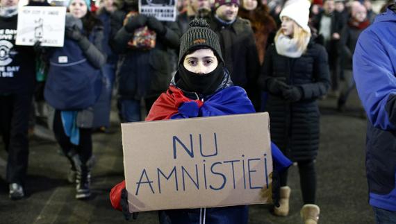 Una niña con una pancarta en que se lee 'Amnistía no'. 