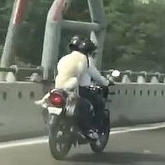 Un hombre y su perro viajan en moto en la India.