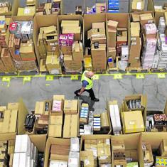 Un trabajador camina entre productos empaquetados en el centro de logística de Amazon en San Fernando (Madrid).