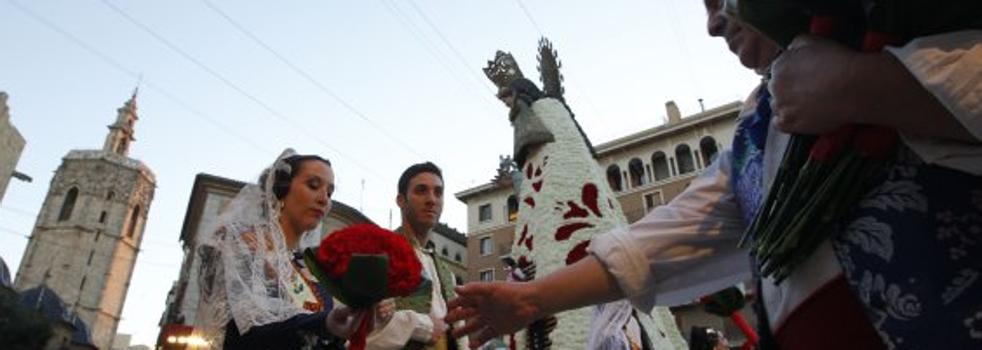 Una fallera entrega su ramo a un vestidor. :: manuel molines