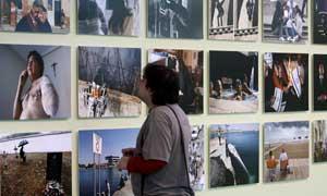 Un hombre observa varias de las fotografías que forman parte de la exposición "Fragments d'un any 2009" que recrea la visión de un año en la Comunitat a través de los objetivos de 38 profesionales. FOTO EFE.
