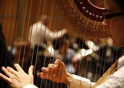 Una joven toca el arpa durante el ensayo de la Orquesta de la Comunitat en el Gran Teatro de Shanghai. / EFE