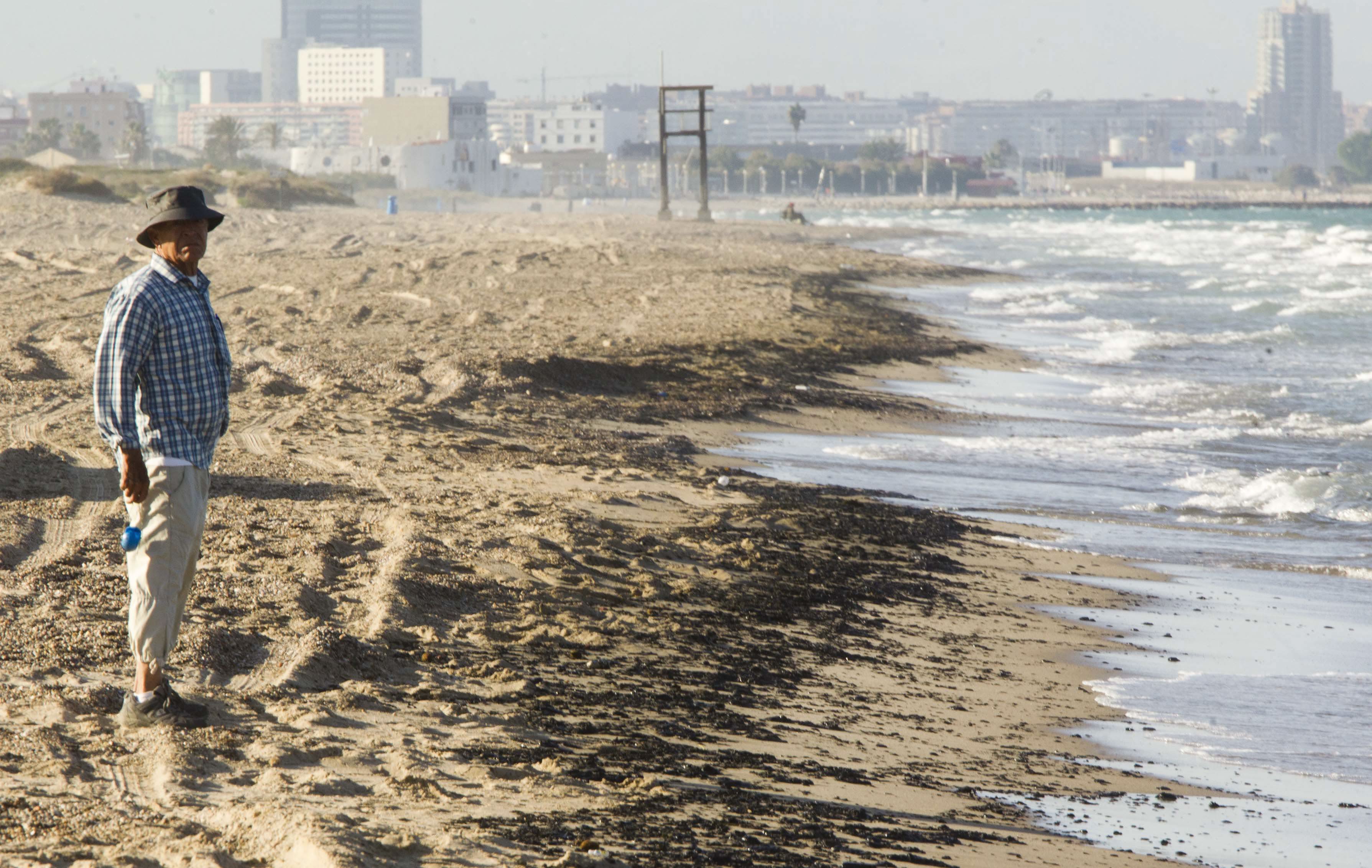 Un hombre pasea por la playa, ayer, ante la zona en la que se encontraban las galletas del vertido.