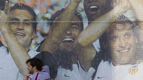 David Albelda se apoya en el mural de sus compañeros de éxitos durante su última temporada como jugadores.