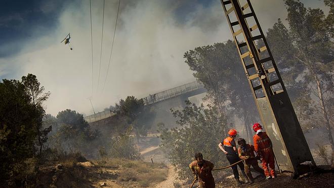 Los bomberos trabajan en la extinción del incendio de Manises. 