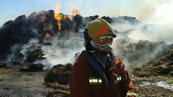 Un bomberos, juntoa a las llamas.