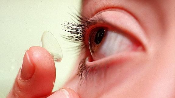 Una mujer se coloca una lentilla.