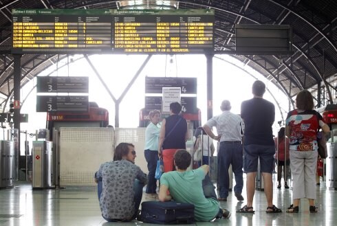 Varias personas esperan la salida de los trenes. :: irene marsilla