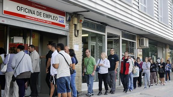 Un grupo de personas hace cola en una oficina del INEM.