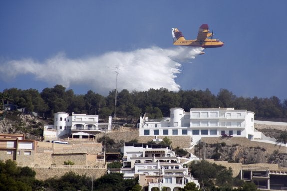 Un air tractor durante los trabajos de extinción del fuego en la zona de La Cuesta de San Antonio, que está repleta de chalés. ::  TINO CALVO