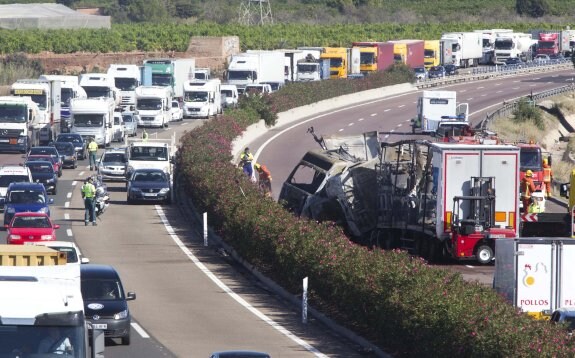 Una cola de vehículos en sentido hacia Alicante a la altura del kilómetro 319 de la A-7, donde colisionaron y ardieron los dos camiones. :: damián torres