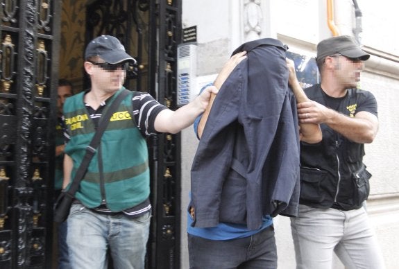 Un trabajador de EICO sale custodiado por agentes de la Guardia Civil tras registrar la sede de la empresa de De Pedro. :: damián torres